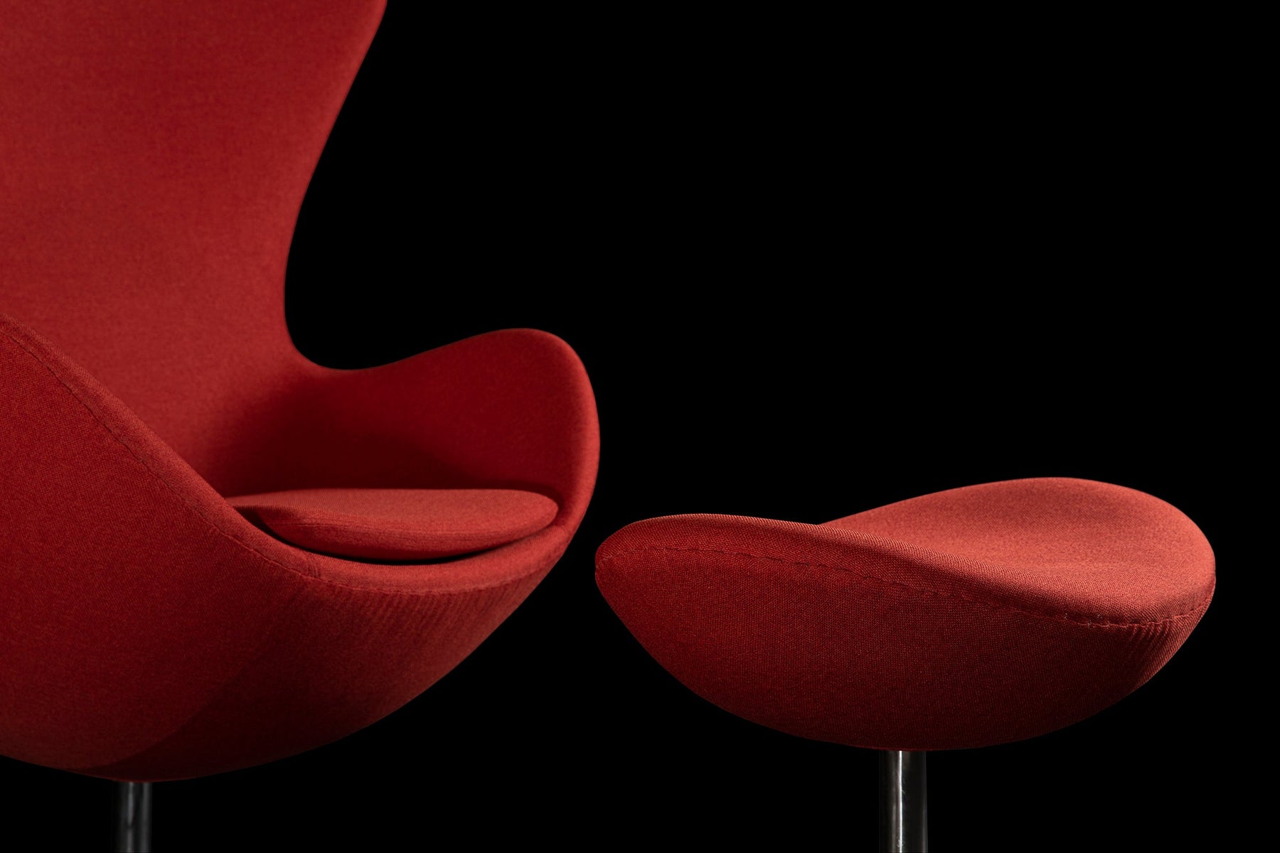 The Tuscan Red fabric jumps away from the jet black background on this photographic banner featuring the infamous Arne Jacobsen Egg Chair & Ottoman set