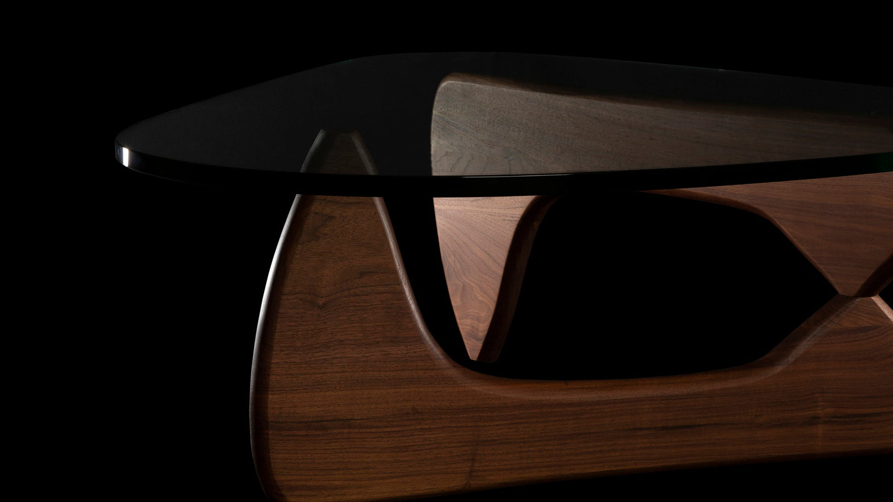 There is something about the dark grain of the Walnut legs of this amazing sultry Isamu Noguchi Coffee table seen with selective light on black surround