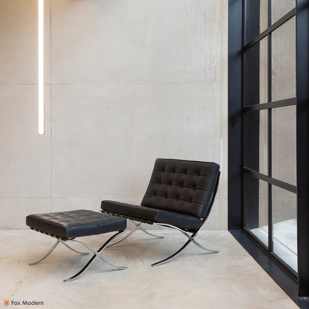 Angled view of black leather Barcelona Pavilion Chair and Ottoman shown in a living space