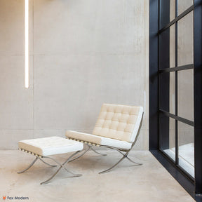 Angled view of white leather Barcelona Pavilion Chair and Ottoman shown in a living space