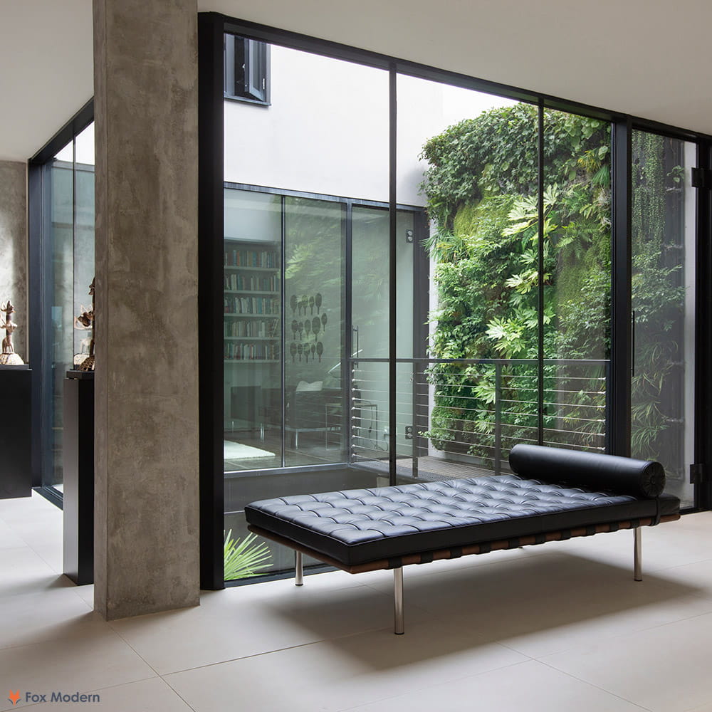 Angled view of black leather Barcelona Pavilion Daybed shown in a living space