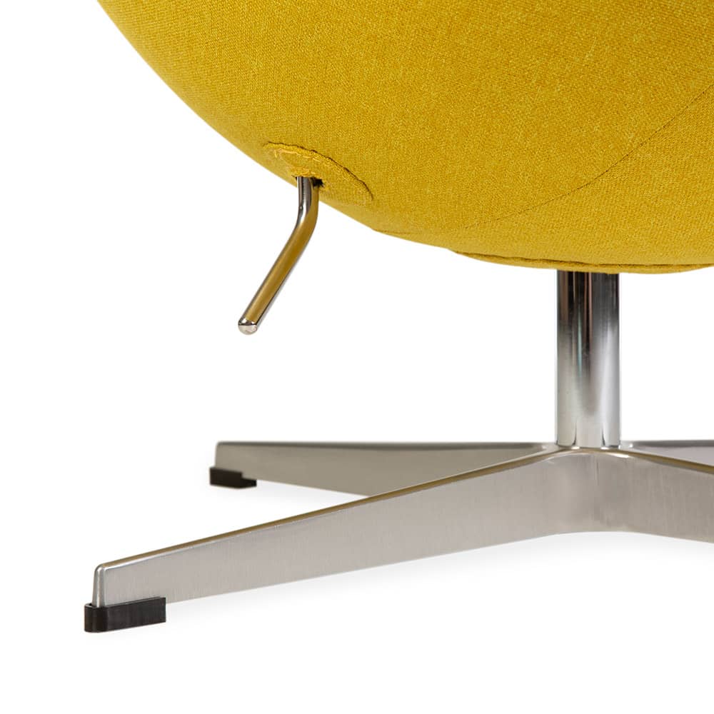 Partial close up view of base and underside of yellow fabric Jacobsen Egg Chair on a white background