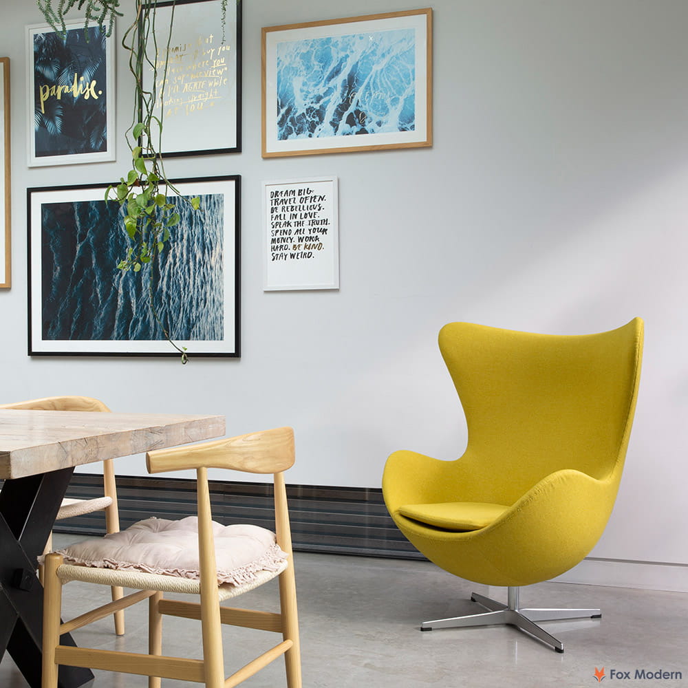 Angled front view of yellow fabric Arne Jacobsen egg chair shown in a living space