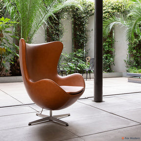 Angled view of tan Arne Jacobsen Egg Chair shown in a living space