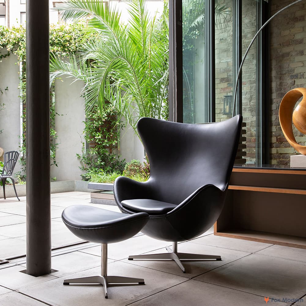 Front angled view of black leather Jacobsen Egg Chair & Ottoman shown in a living space