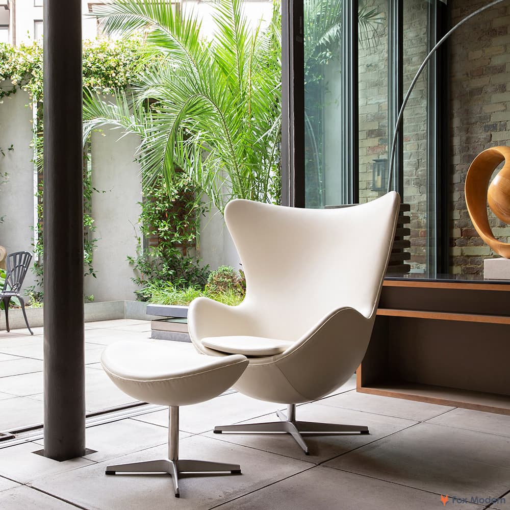 Front angled view of white leather Jacobsen Egg Chair & Ottoman shown in a living space