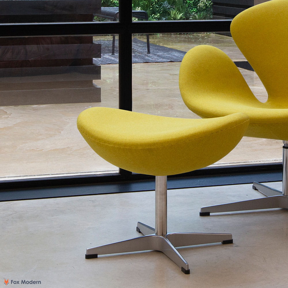 Angled view of yellow fabric Arne Jacobsen ottoman shown in a living space