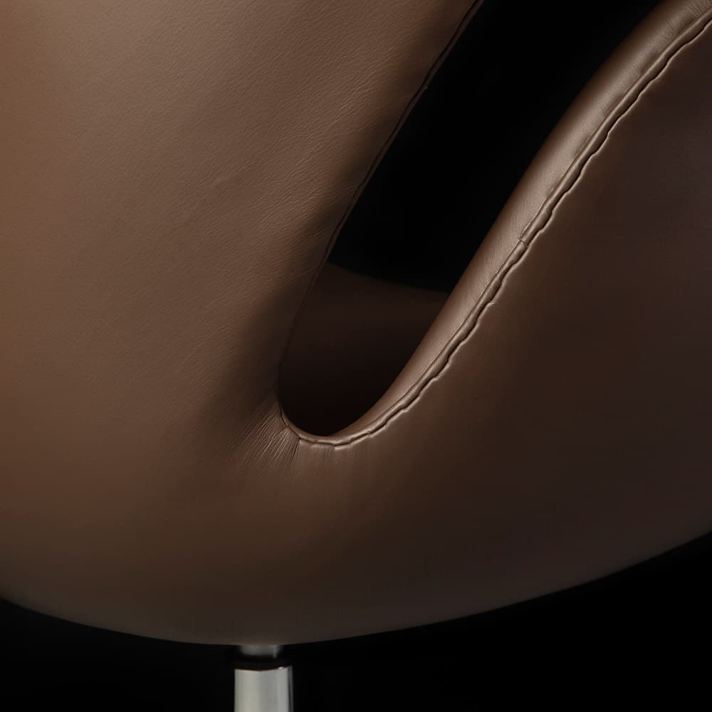 Close up rear view of the brown leather Arne Jacobsen Swan Chair on a black background