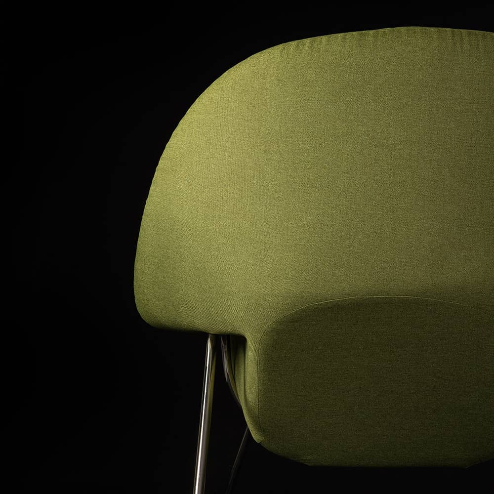 Rear view of the green fabric Eero Saarinen Womb Chair on black background