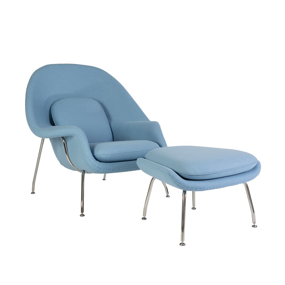Angled front view of the blue fabric Saarinen Womb Chair and Ottoman on a white background
