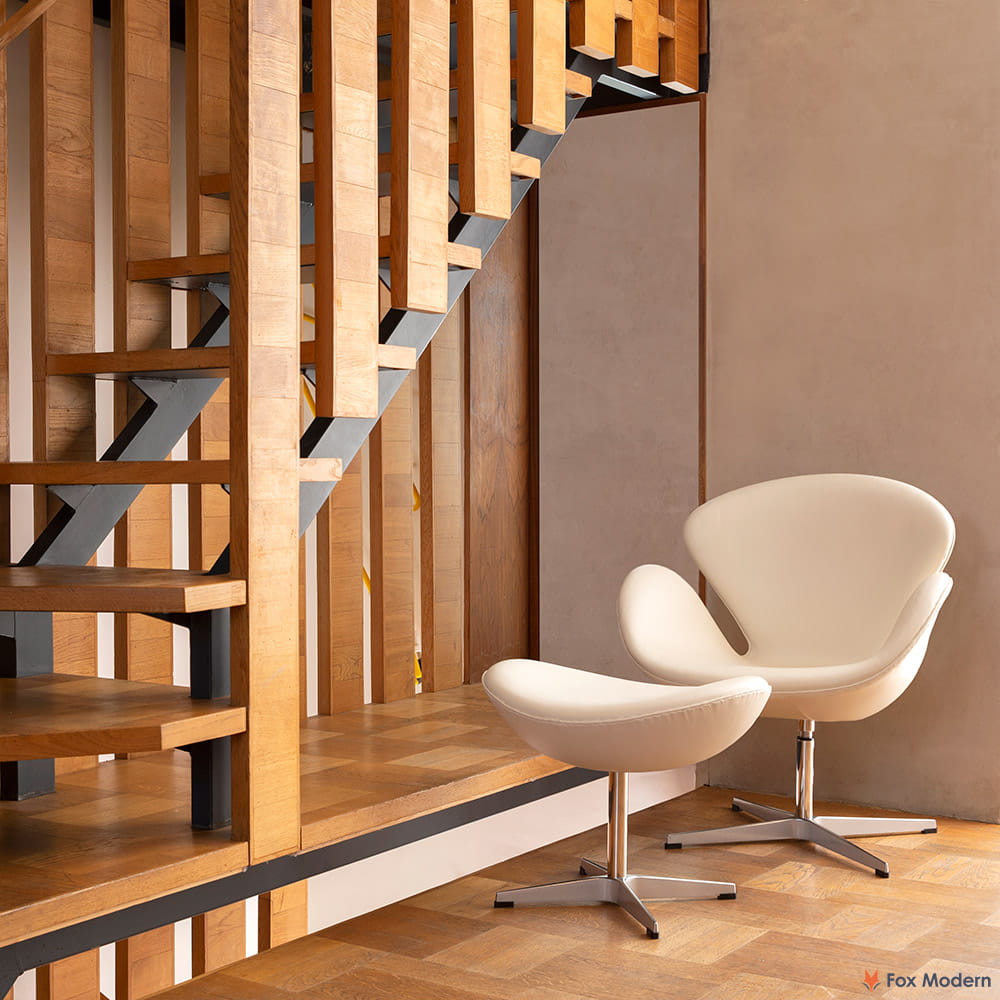 Angled front view of white leather Jacobsen Swan Chair & Ottoman shown in a living space