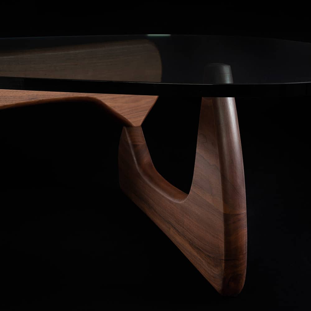 Close up side view of walnut Noguchi Coffee Table on black background